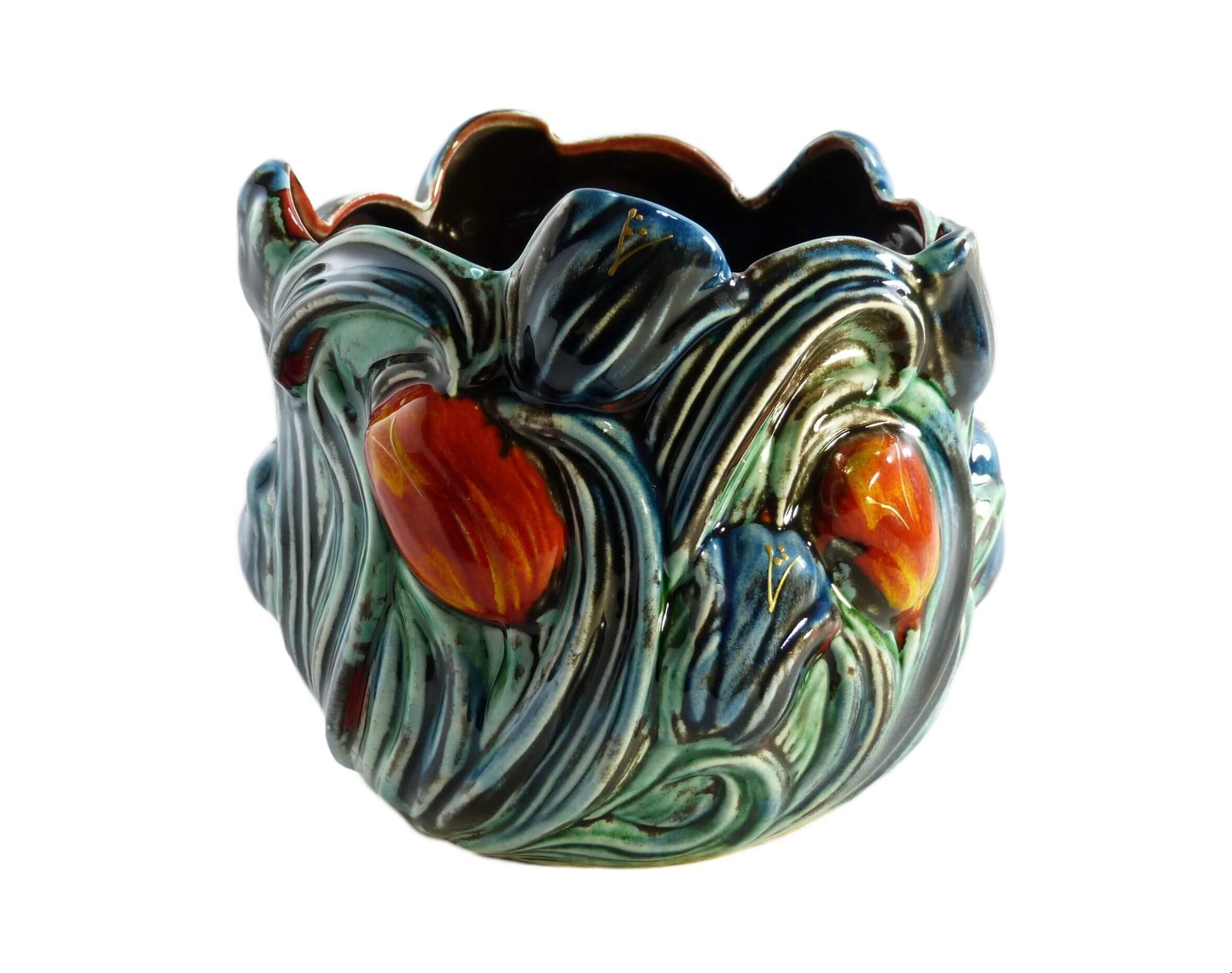 A small shiny plant pot with red and blue tulips  and green leaves that cover the entire pot. The interior is black.