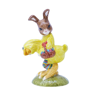 The bunny is dressed in a yellow chicken costume and is holding a basket of eggs.