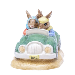 Two Bunnykins sitting in a green sports car with white trim. The yellow number plate is Bun 2.