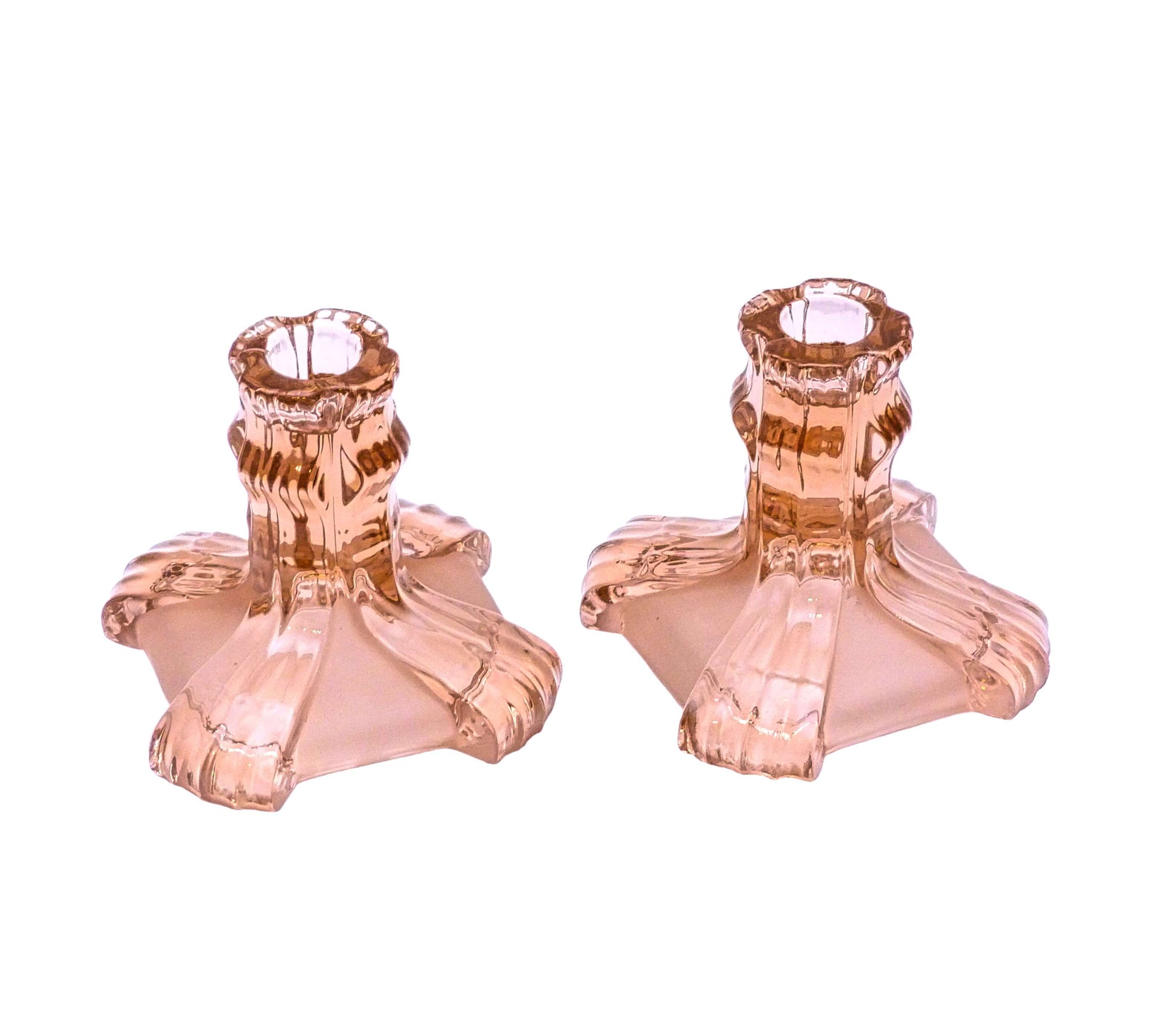 The pair of candle holders are made of clear and frosted pink glass with a square base.