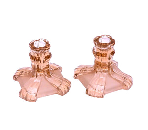 The pair of candle holders are made of clear and frosted pink glass with a square base.