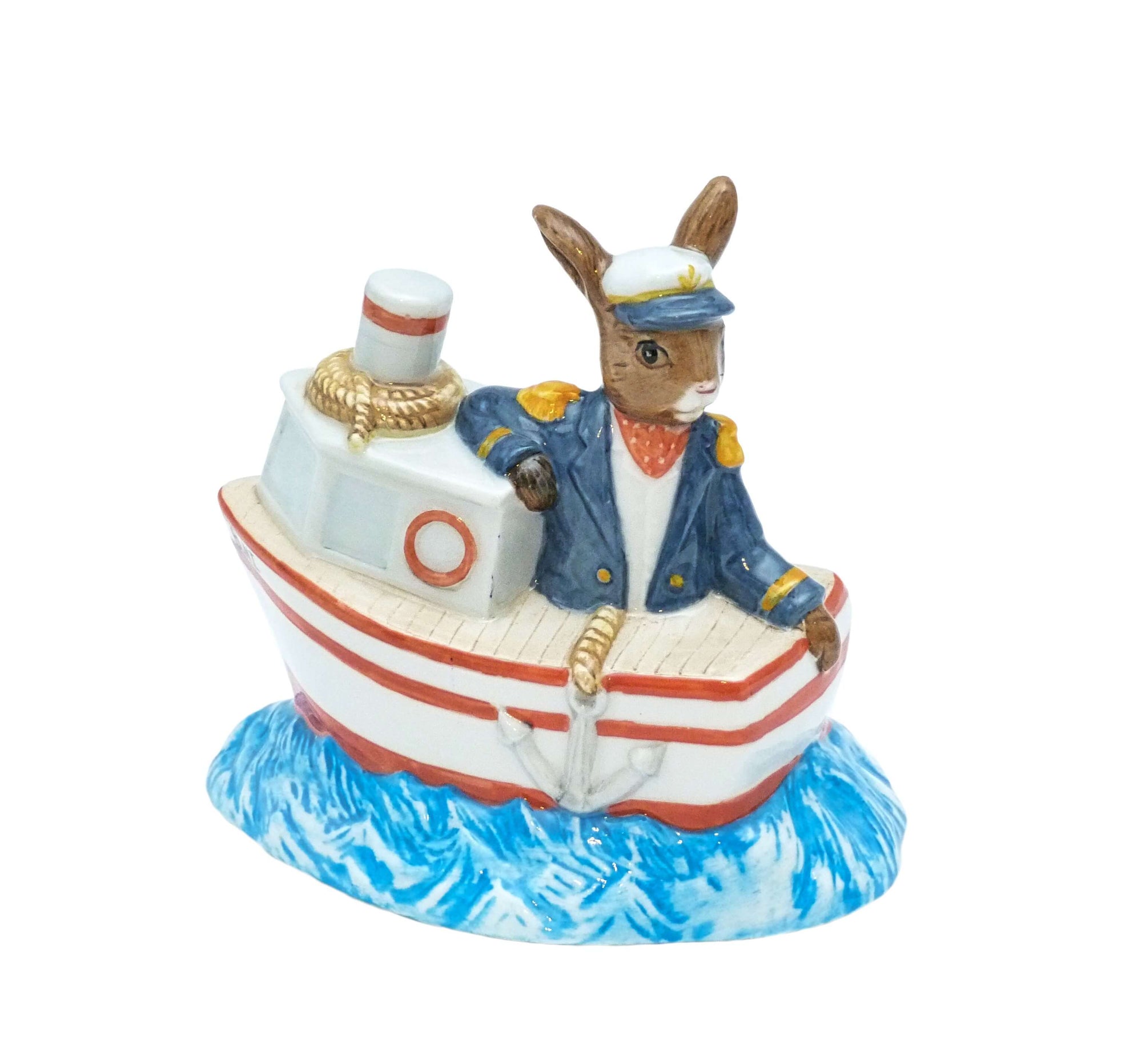 The bunnykin is in his boat, he is wearing a sailor cap and blue coat with gold epaulets.