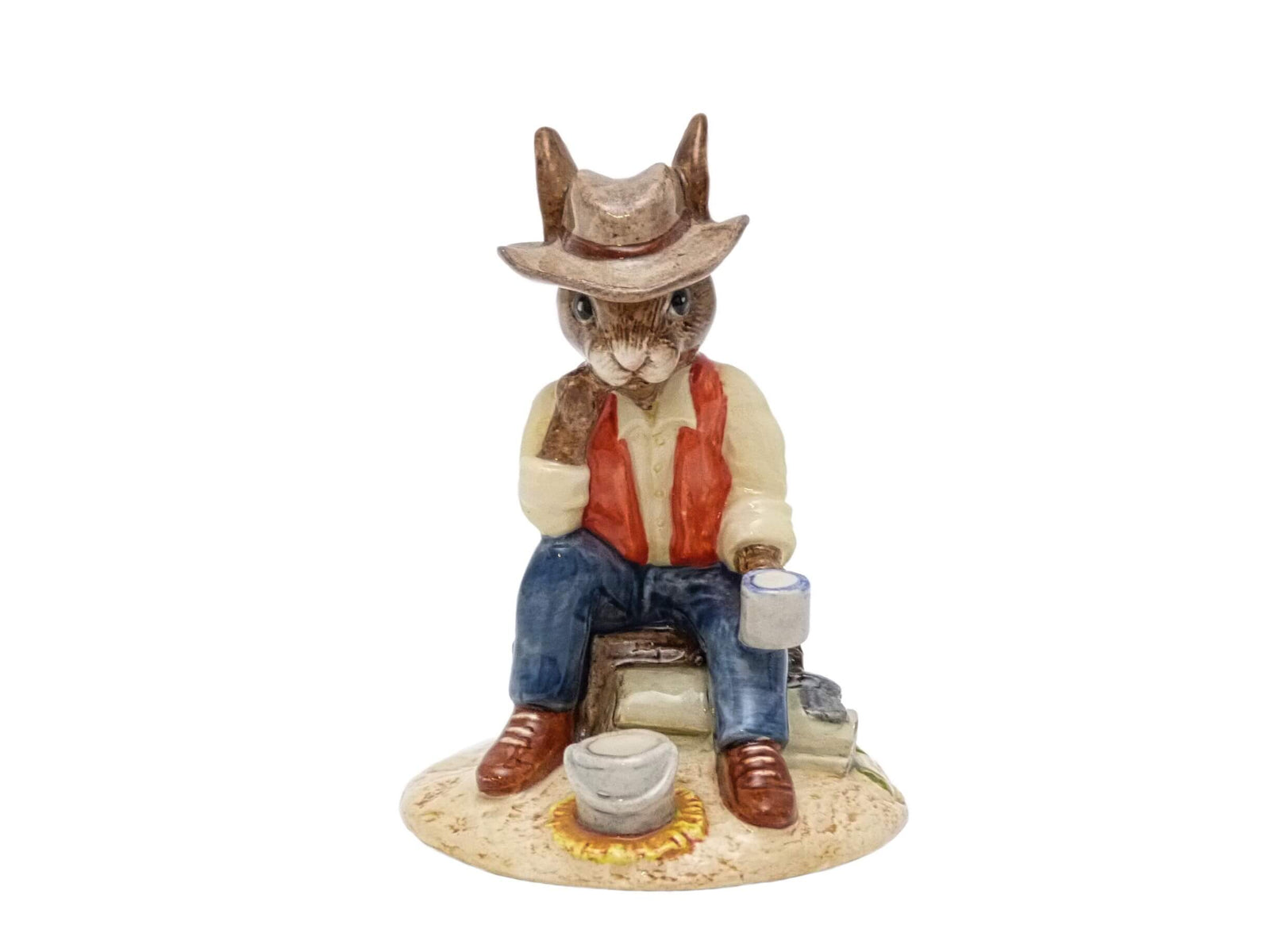 This is a Swaggie sitting by a campfire with a billy on the fire, drinking a mug of tea.